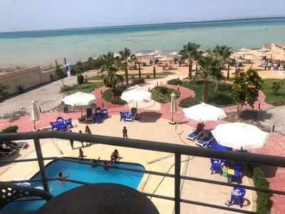 a view of a resort with a swimming pool and the ocean at sea front apartment in Hurghada