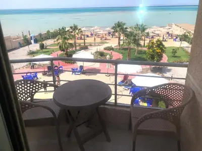 a balcony with a table and chairs and a view of the beach at sea front apartment in Hurghada