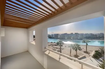 a balcony with a view of the beach and buildings at Lofty & Lavish 3 BDR Swan Lake El Gouna in Hurghada