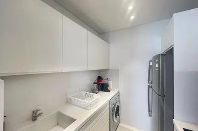 a kitchen with white cabinets and a refrigerator at Lofty & Lavish 3 BDR Swan Lake El Gouna in Hurghada