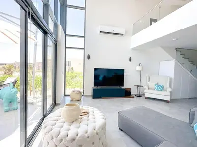 a living room with a couch and a tv at Beachfront Spacious Somabay Loft in Hurghada