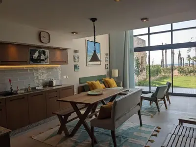 a kitchen and living room with a table and chairs at Modern Beachfront 1BR Loft with Garden in Somabay in Hurghada