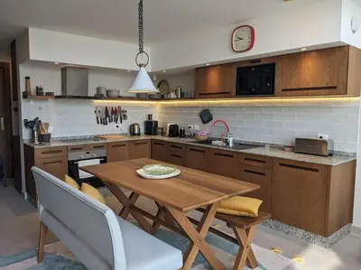 a kitchen with a wooden table and a clock on the wall at Modern Beachfront 1BR Loft with Garden in Somabay in Hurghada