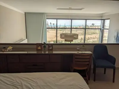 a bedroom with a bed and a chair and a window at Modern Beachfront 1BR Loft with Garden in Somabay in Hurghada