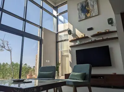 a living room with a table and chairs and a tv at Modern Beachfront 1BR Loft with Garden in Somabay in Hurghada