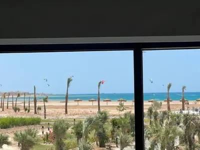 a view of a beach with palm trees and the ocean at Somabay Seaview 1BR Loft 2 Mins to Beach & Pool in Hurghada