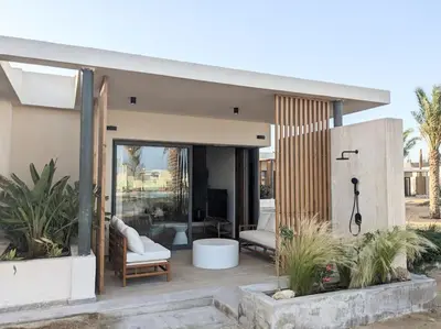 a house with a glass door and a patio at Magical Cabana Steps From Beach & Pool in Hurghada