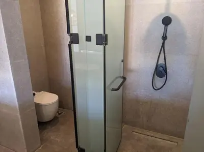 a bathroom with a glass shower with a toilet at Magical Cabana Steps From Beach & Pool in Hurghada