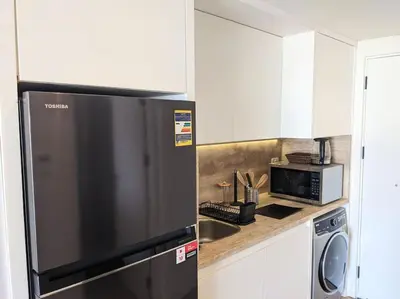 a kitchen with a black refrigerator and a microwave at Magical Cabana Steps From Beach & Pool in Hurghada