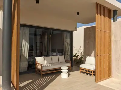 a porch with a couch and a chair on a patio at Somabay 2BR Grand Cabana Minutes From Pool & Sea in Hurghada
