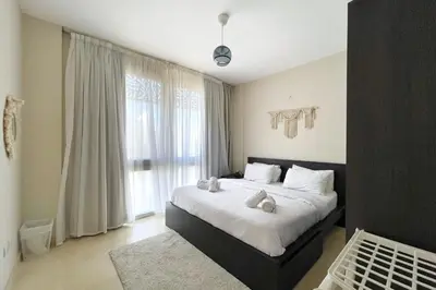 a bedroom with a bed and a large window at Minimal & Mere 1 BDR Mangroovy Free Beach & Pool in Hurghada