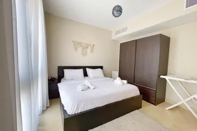 a bedroom with a bed with white sheets at Minimal & Mere 1 BDR Mangroovy Free Beach & Pool in Hurghada