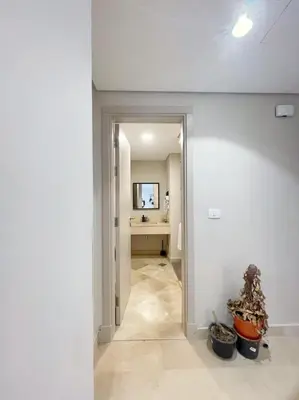 a hallway with a mirror and a table in a room at Minimal & Mere 1 BDR Mangroovy Free Beach & Pool in Hurghada