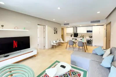 a living room with a couch and a tv at Scenic Pool Front 1 BDR Mangroovy Free Pool & Beach in Hurghada