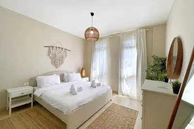 a bedroom with a white bed and a large window at Embellished 2BDR Penthouse Mangroovy Free Pool & Beach in Hurghada