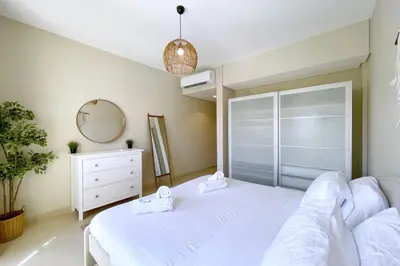 a bedroom with a bed and a dresser and a mirror at Embellished 2BDR Penthouse Mangroovy Free Pool & Beach in Hurghada