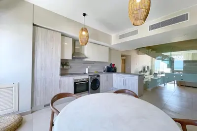 a kitchen and dining room with a table and chairs at Embellished 2BDR Penthouse Mangroovy Free Pool & Beach in Hurghada