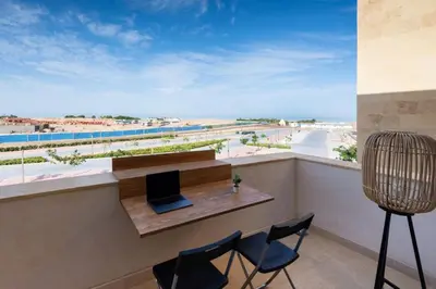 a balcony with a table and chairs and a view of the beach at Vogue & Idyllic 2 BDR Mangroovy Free Pool & Beach Access in Hurghada