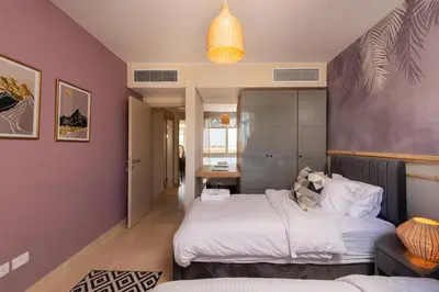 a bedroom with two beds and a purple wall at Vogue & Idyllic 2 BDR Mangroovy Free Pool & Beach Access in Hurghada