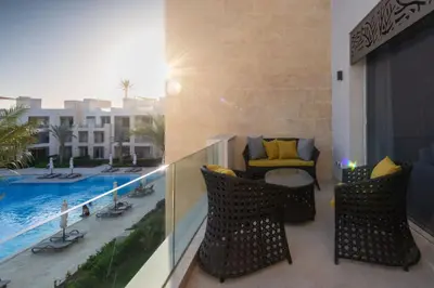 a balcony with a view of a swimming pool at Vogue & Idyllic 2 BDR Mangroovy Free Pool & Beach Access in Hurghada