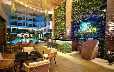 a restaurant with a green wall with tables and chairs at Imperial Beach Resort in Hurghada