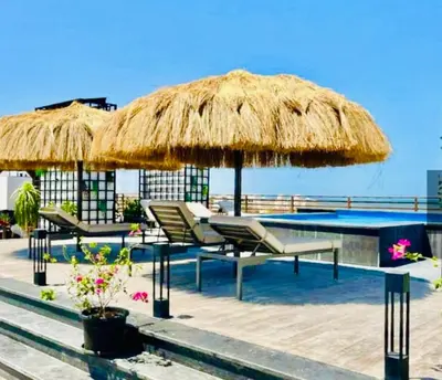 a pool with chairs and a large straw umbrella at Imperial Beach Resort in Hurghada
