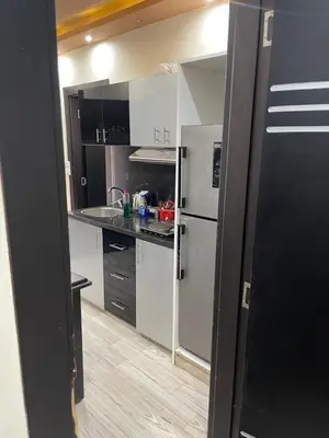 a kitchen with white cabinets and a refrigerator at hotel mirage aqua park in Hurghada