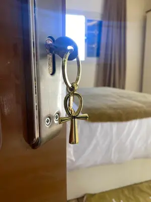a door latch with a key on a bed at Appartement avec rooftop au cœur de Louxor vue sur le Nil in Jazīrat al ‘Awwāmīyah