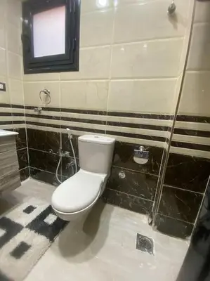 a bathroom with a white toilet and a window at Appartement avec rooftop au cœur de Louxor vue sur le Nil in Jazīrat al ‘Awwāmīyah