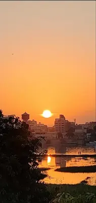 a sunset over a city with a body of water at Pro Luxor guest house in Luxor