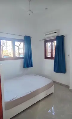 a bedroom with a white bed with blue curtains at Pro Luxor guest house in Luxor