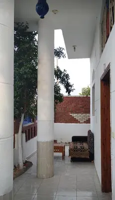 a patio with a couch and a table in a building at Pro Luxor guest house in Luxor