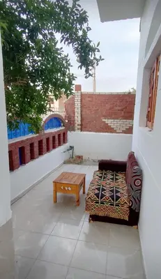 a patio with a couch and a coffee table at Pro Luxor guest house in Luxor