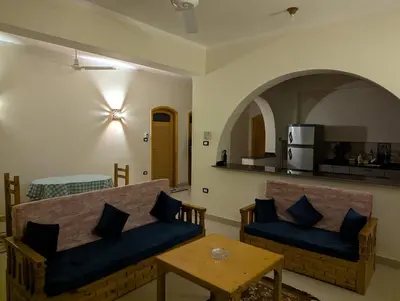 a living room with two blue couches and a table at Pharaohs Apartments in Luxor
