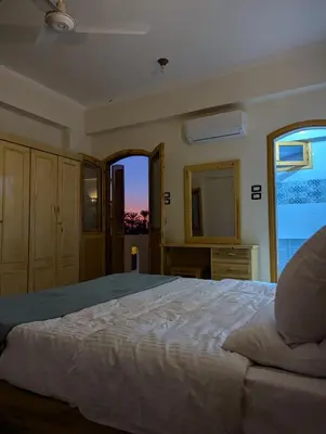 a bedroom with a large bed and a window at Pharaohs Apartments in Luxor