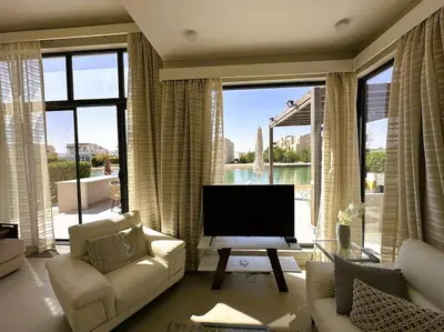 a living room with a couch and a television at Luminous 4BR Villa, Free Pool & Lagoon Access At Gouna in Hurghada