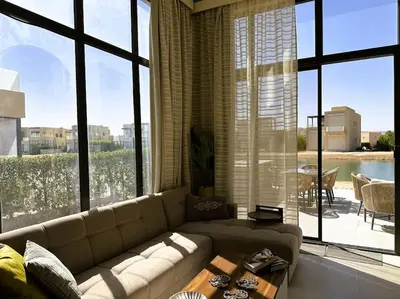 a living room with a couch and large windows at Luminous 4BR Villa, Free Pool & Lagoon Access At Gouna in Hurghada