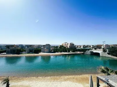 a large body of water with buildings in the background at Luminous 4BR Villa, Free Pool & Lagoon Access At Gouna in Hurghada
