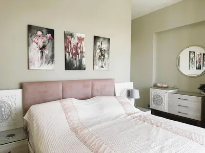 a bedroom with a pink bed and some paintings on the wall at Luminous 4BR Villa, Free Pool & Lagoon Access At Gouna in Hurghada