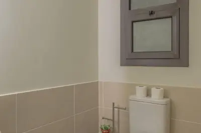 a bathroom with a mirror and a toilet in it at Comfy 2BR in Shedwan El Gouna Garden BBQ, Pool, Lagoon in Hurghada