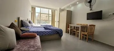 a bedroom with a bed and a table and a television at Scandic Resort in Hurghada