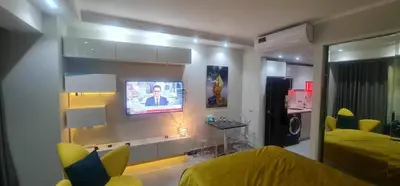 a bedroom with a tv on a wall with a bed at Scandic Resort in Hurghada