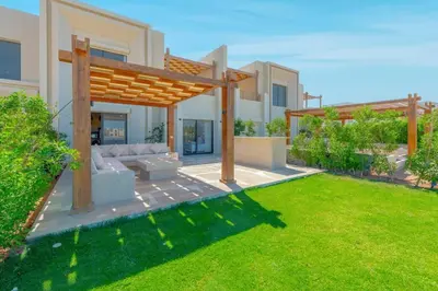 a backyard with a couch and a wooden pergola at Charming 2-Lvl 3BR Lagoon Home in Shedwan El Gouna, Pool Access in Hurghada