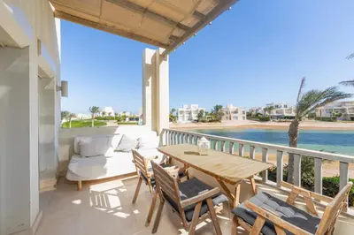 a patio with a table and chairs on a balcony at Beautiful apartment with roof terrace in Joubal in Hurghada