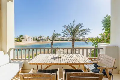 a table and chairs on a balcony with a view of the water at Beautiful apartment with roof terrace in Joubal in Hurghada