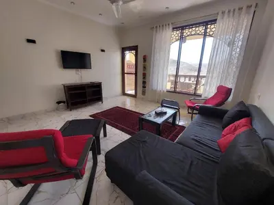 a living room with a couch and chairs and a tv at Carter Guesthouse Luxor 2 in ‘Ezbet Abu Ḥabashi