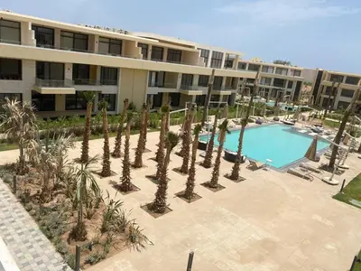 an apartment complex with a swimming pool and palm trees at Studio El Gouna G Cribs Hotel in Hurghada
