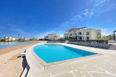 a swimming pool in front of a villa at Cordial 2 BDR w Pool Access Cyan El Gouna in Hurghada