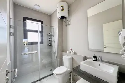 a bathroom with a shower and a toilet and a sink at Cordial 2 BDR w Pool Access Cyan El Gouna in Hurghada