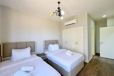 a bedroom with two beds with white sheets at Cordial 2 BDR w Pool Access Cyan El Gouna in Hurghada
